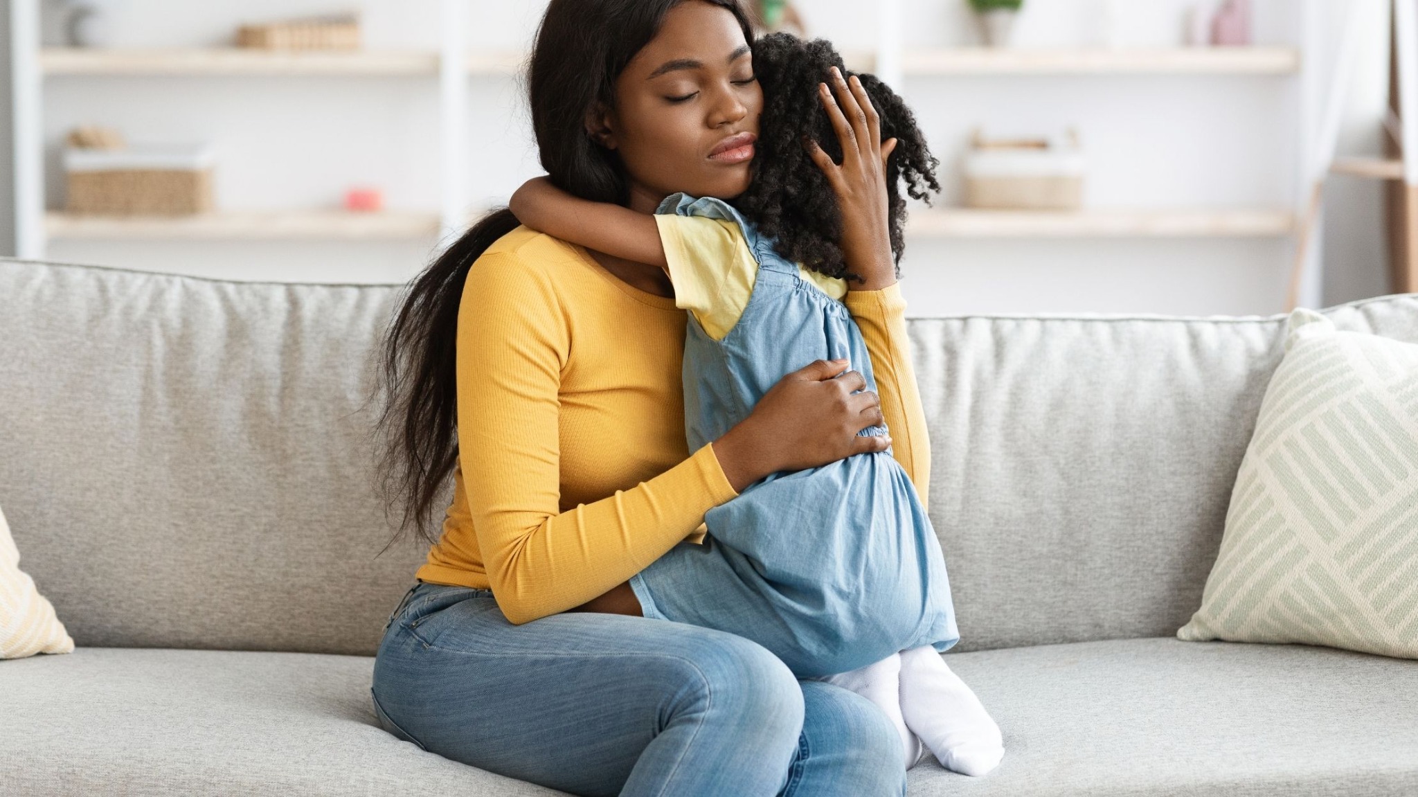 Black mother comforting her daughter at home